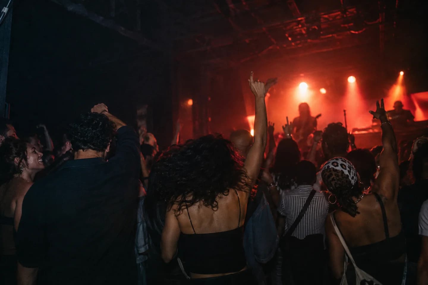 Friends dancing under red and blue light at an intimate live music venue